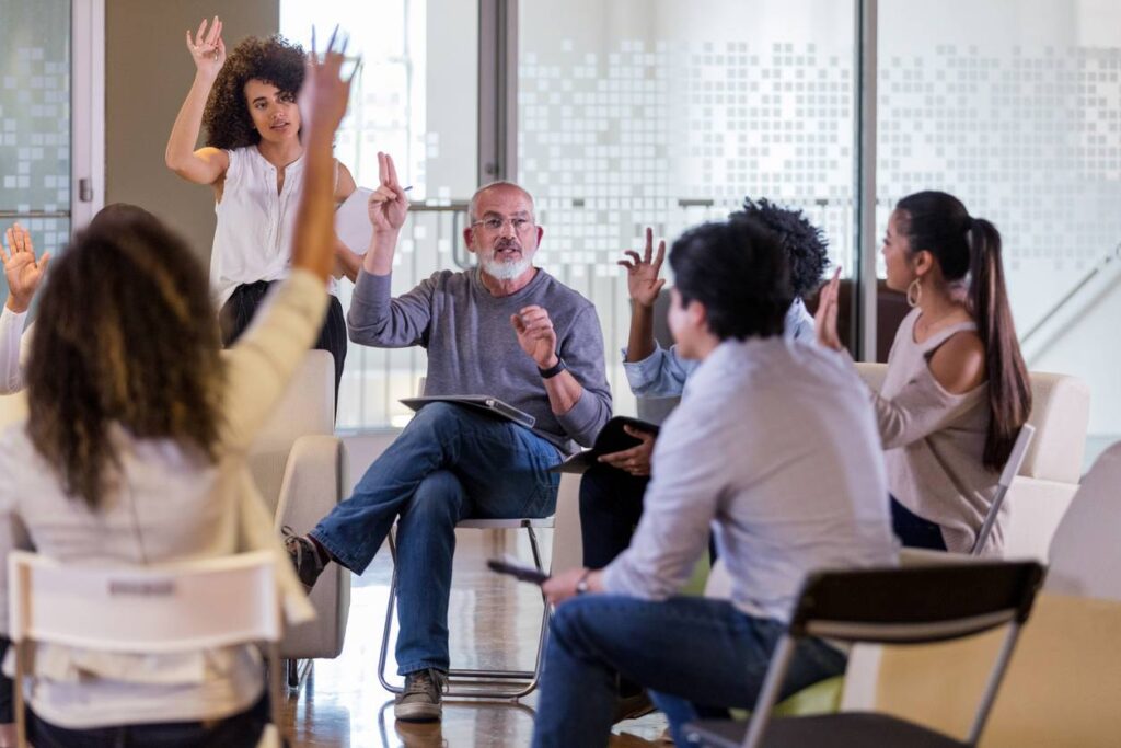 mature male hoa president leads his neighbors in a vote during an hoa meeting