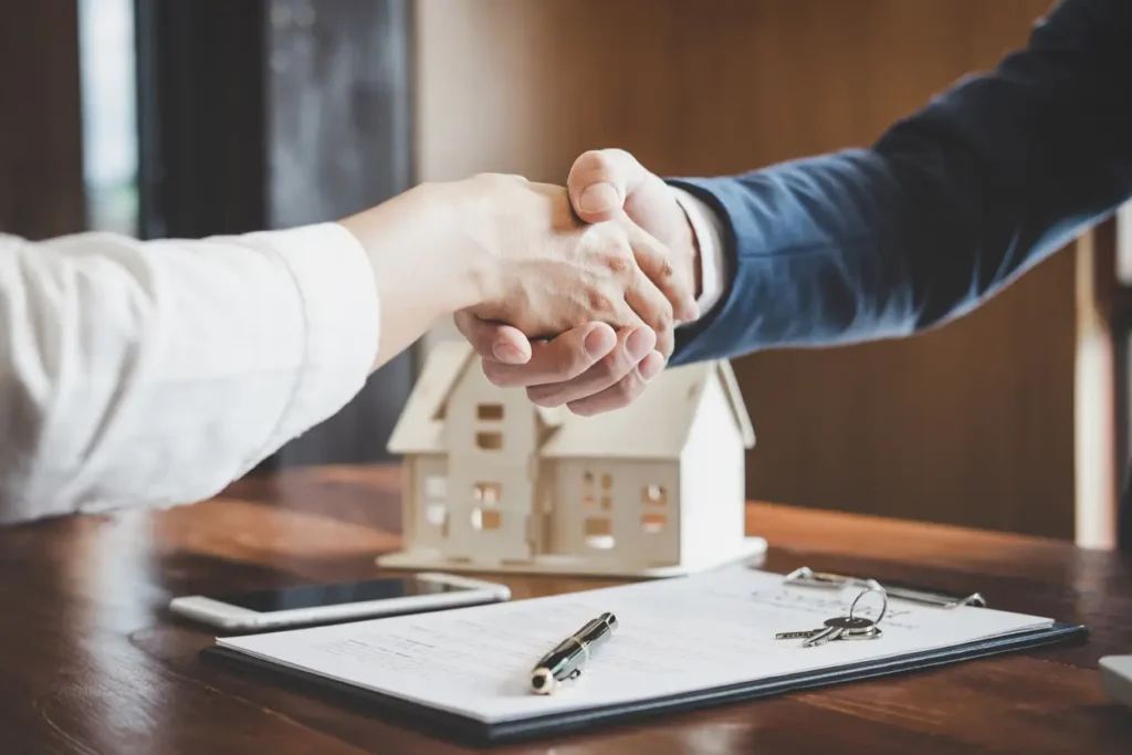 real estate agent and customers shaking hands together celebrating finished contract after about home insurance and investment loan handshake and successful deal