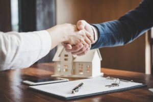 real estate agent and customers shaking hands together celebrating finished contract after about home insurance and investment loan handshake and successful deal